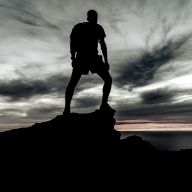 a person standing on the top of a mountain during sunrise